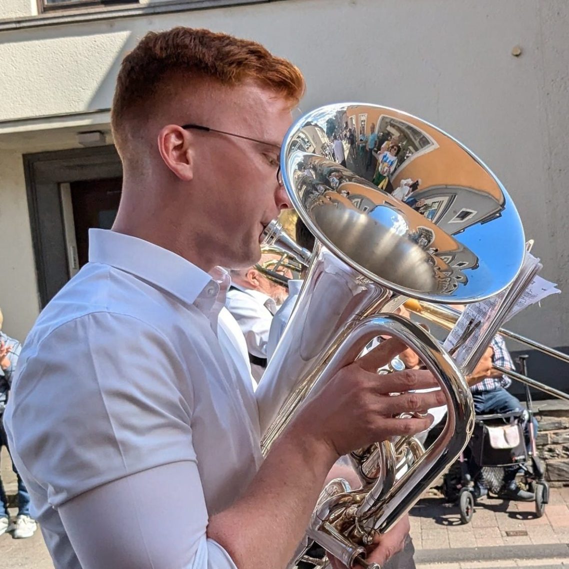Jonas Klar als leidenschaftlicher Musiker – spielend mit Euphonium beim Festumzug, weißes Hemd, Musik in Bewegung