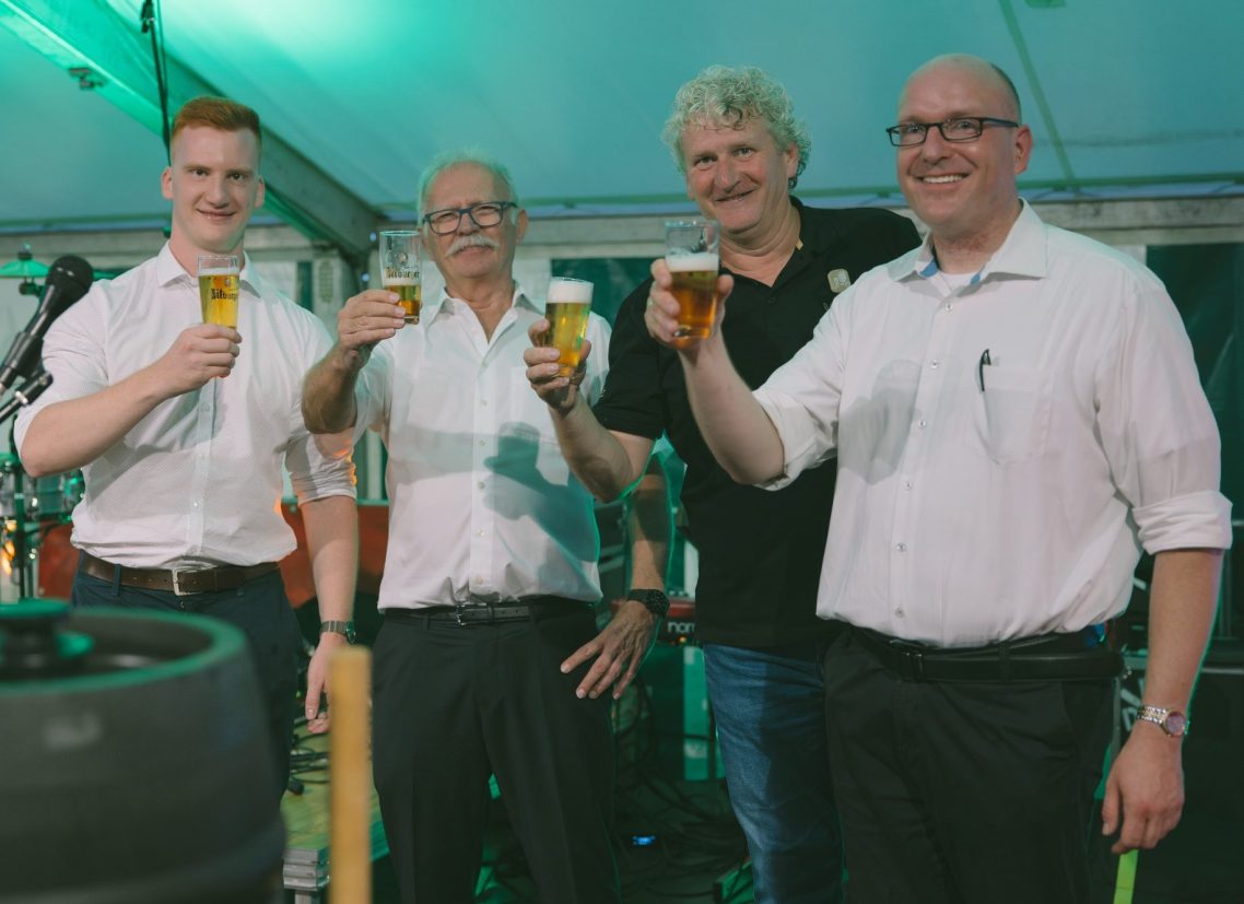 Jonas Klar mit dem Orga-Team des Schweicher Heimat-, Wein- und Erntedankfestes – Anstoßen mit Biergläsern nach der feierlichen Eröffnung